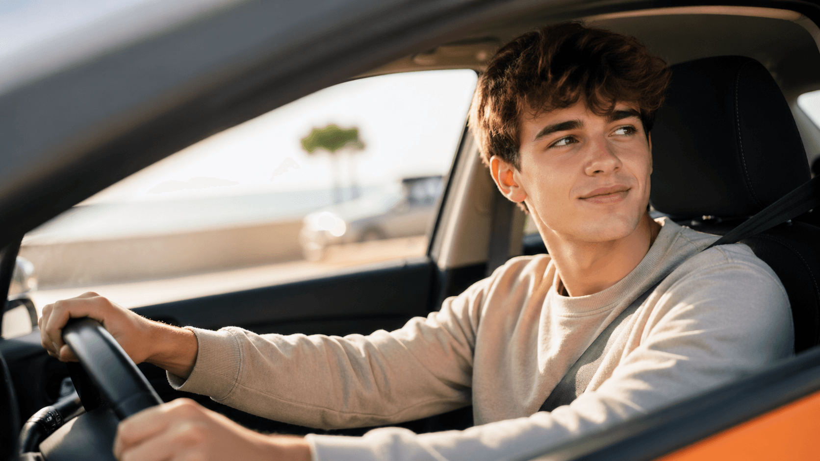 Jeune conducteur au volant d'une voiture sur une route, prêt pour son premier trajet